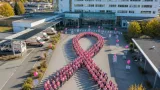 LKH Feldkirch: Mitarbeiterinnen bilden Pink-Ribbon-Schleife für Brustkrebsfrüherkennung